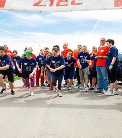 Foto: Große Gruppe von Teilnehmenden setzt zum Laufen für ein Rennen im Freien ein.
